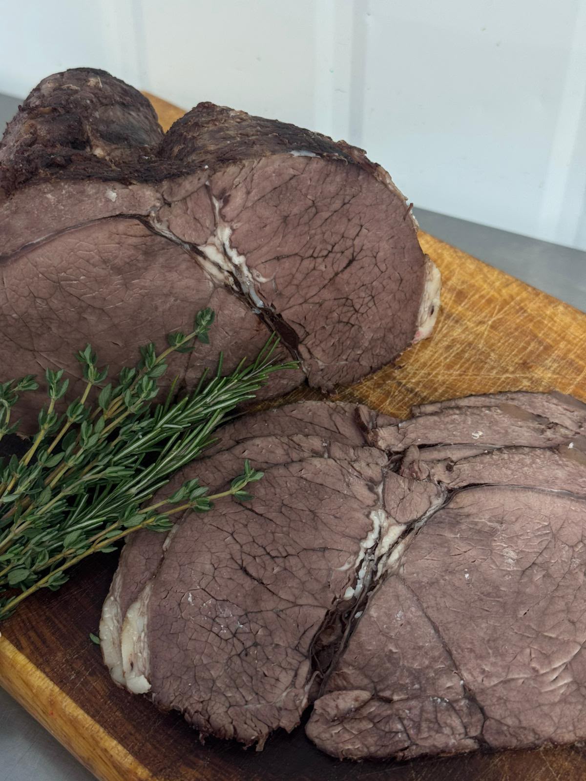 Premium sliced roast Irish beef on a wooden board from Herterich Artisan Meats