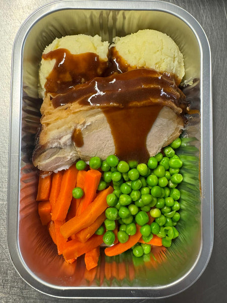 Herterich Roast Pork Dinner ready meal with roast pork, mashed potatoes, gravy, carrots, and peas in an aluminum tray.