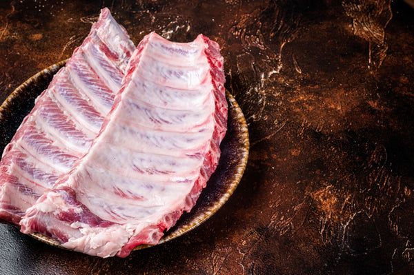 Raw bacon ribs on a dark surface