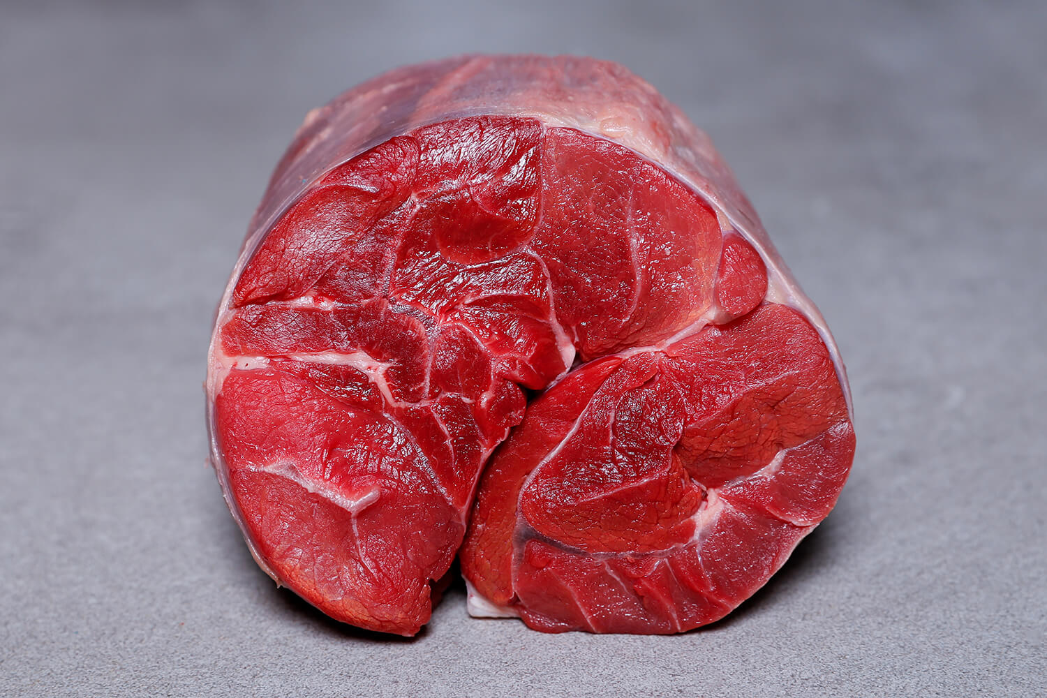 Freshly cut raw Irish Beef Shin and Heel showing rich colour and texture on a grey background