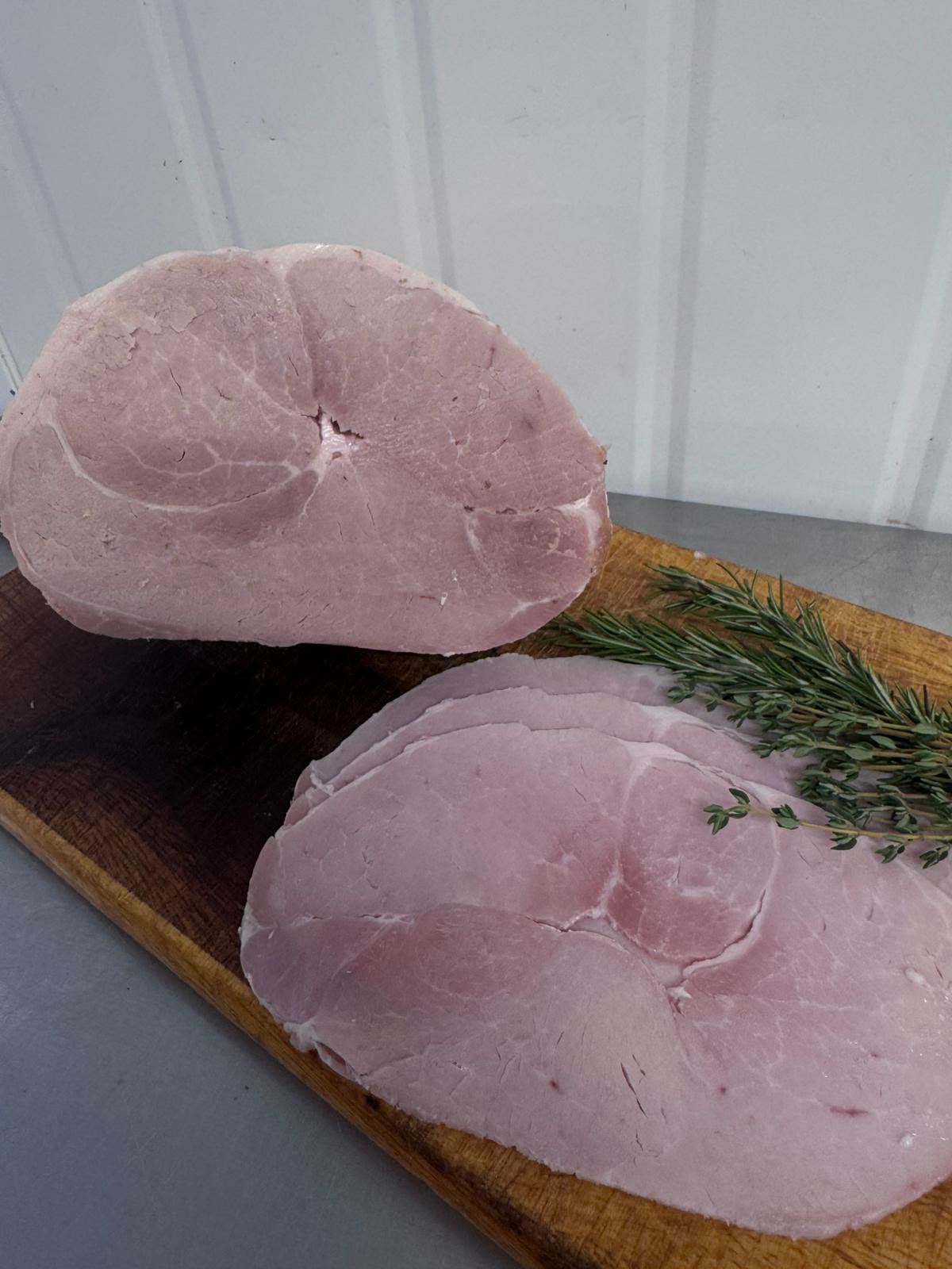 Slow cooked sliced Irish ham on a wooden board from Herterich Artisan Meats