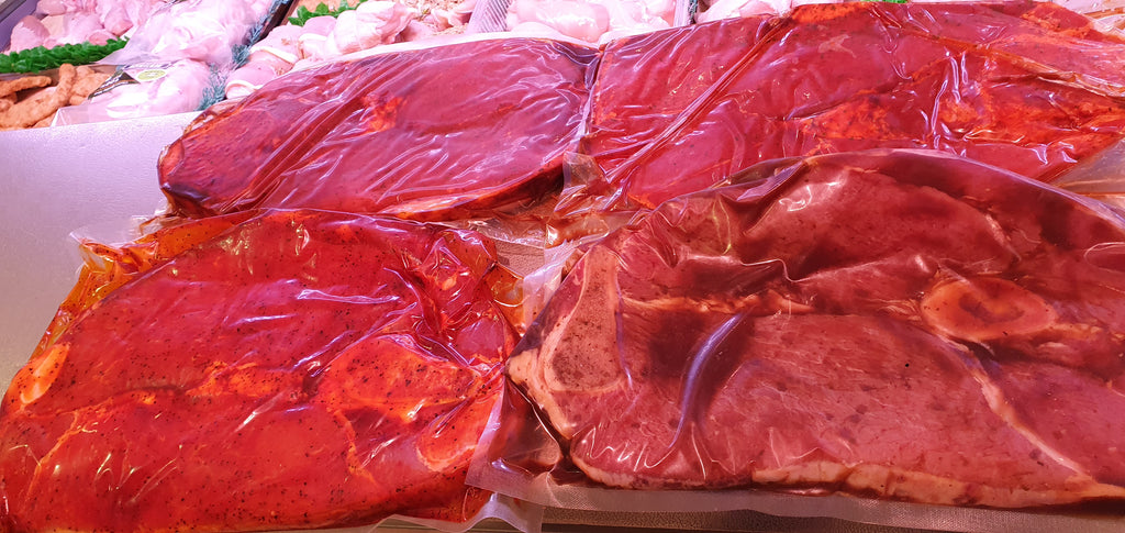 Several large, fresh South African Texan beef steaks displayed, some with marbling visible, likely prepared for grilling.
