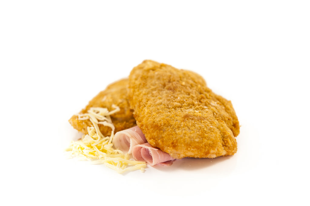Two raw Chicken Cordon Bleu portions with a golden crumb, filled with Irish chicken, ham, and cheddar cheese.