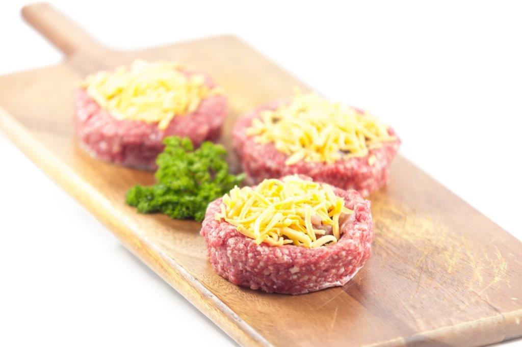 Two raw Gourmet Irish Beef Burgers (200g each) stuffed with smoked bacon, BBQ sauce, and topped with red cheddar cheese.