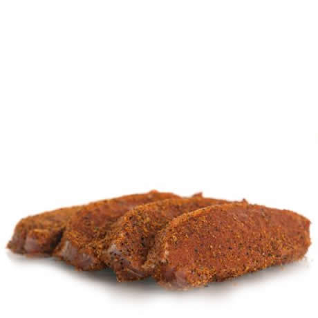 Four Herterich's raw boneless pork loin chops, generously coated in a peppered seasoning, ready to cook.